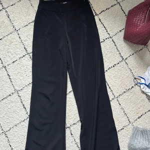 Svarta vida kostymbyxor byxor från bikbok - Svarta byxor från bikbok med hög midja och vida ben. Byxorna har en mjuk och  känsla, perfekta för en avslappnad stil. Passar bra till både sneakers och sandaler.