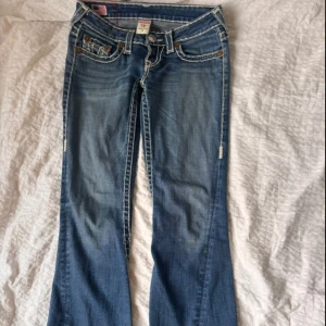 Blå fatstitch bootcut, lowwaist jeans från True Religion - Säljer mina älskade jeans från True Religion med bootcut passform. Jeansen har vitt fatstitch och låg midja. Jättefint skick, jätte kraftigt material, då det är en gammal modell. 