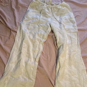 Vita/beige linnebyxor med dragsko - Säljer ett par ljusbeige linnebyxor i storlek XS med resår och dragsko i midjan. Byxorna har raka ben och två stora fickor bak. Perfekta för varma dagar och en avslappnad stil.