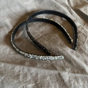 Jättefina diadem  - Två svarta diadem täckta med glittriga stenar. Perfekta för att ge en extra touch till din look. Diademen är smala och har en elegant form som sitter bekvämt på huvudet.  