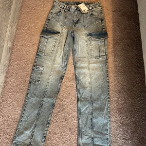 Grå/blå cargopants från H&M (Snygga) - Säljer ett par grå/blå jättesnygga cargopants från H&M med flera stora fickor på sidorna och bak. Perfekta för en avslappnad och trendig stil. Ställ frågor om du har några❤️