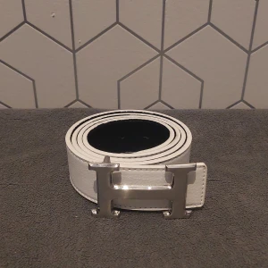 Bälte med H-spänne - Säljer ett stilrent vitt bälte med ett stort H- spänne i silver. || 110 cm långt 