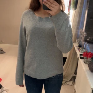 Ljusgrå stickad tröja - Mysig ljusgrå stickad tröja med rund halsringning och långa ärmar. Tröjan har en enkel och klassisk design med ribbade muddar vid ärmslut och nederkant. Perfekt på en kylig sommarkväll💕