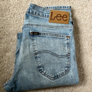 Ljusblå Lee Daren jeans W29 L32 - Säljer ett par klassiska ljusblå Lee Daren jeans med rak passform och dragkedjegylf. Jeansen har fem fickor och subtila slitningar för en avslappnad look. Perfekta till vardags och passar till det mesta.