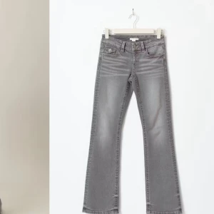 chunky low flare jeans från Gina Tricot - Flare jeans från Gina Tricot Young med utsvängda ben. Jeansen är gråa och har låg midja. De har resår i midjan, dragkedjegylf, låg stretch, framfickor och bakfickor med knapp och lock.