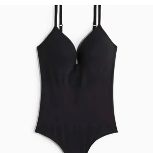 Svart body H&M - En stilren svart body med vadderade kupor och justerbara axelband. Klassisk modell med v-ringning framtill och slät design utan extra detaljer. Perfekt för en utekväll 