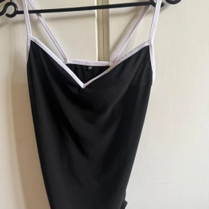 Body - Svart body med vita kanter. Sparsamt använd.