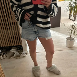 Ljusblå jeansshorts från Zara - Säljer ett par ljusblå jeansshorts med slitningar från Zara. Shortsen har avslappnad passform och knappgylf. Perfekta för varma dagar!!💕