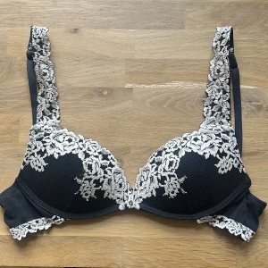 Svart push up-bh med spetsdetaljer från intimissimi - Säljer en svart push up-bh Gioia från intimissimi med vackra vita spetsdetaljer längs kuporna och längs banden