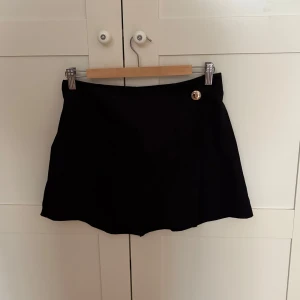 Svart skort med guldknapp - Aldrig använd. 