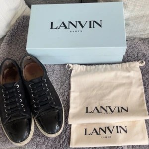 Lanvin DBB1 Patent Cap Toe - Säljer nu tyvärr mina utan tvekan mest pålitliga och snyggaste skor jag någonsin ägt. Ett par klockrena sneakers rakt igenom. Ägt dom sedan i höstas och har tagit väldigt väl hand om dom. Hållbarheten på dessa skor är GULD! Skick 8/10 då de har vanliga, mindre slitningar på insidan av skon. Priset är ej hugget i sten. Original box med original dustbagsen kommer med på köpet. Storlek 11 vilket motsvarar 45 men passar mig som har 46 perfekt.
