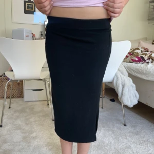 Svart långkjol från LMTD - Säljer en svart långkjol från LMTD i storlek XS. Kjolen har en rak passform och en liten slits på sidan för extra rörelsefrihet. Perfekt att styla med en enkel topp eller hoodie.