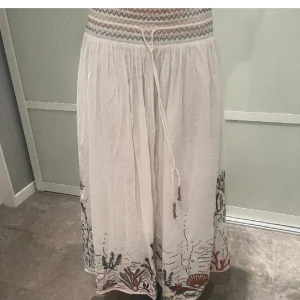 Vit långkjol med broderade detaljer - Nypris 800! Säljs inte längre, efterfrågad och otroligt snygg. Perfekt till sommaren och sjukt trendig. Säljer då den är för liten för mig, så fina detaljer som gör den extra somrig 🌞