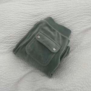 Gröna juicy byxor - Säljer ett par juicy i storlek XXS, i färgen classic velour, säljs pågrund av att de ej passar och används ej. Byxorna är i bra skick och är uppsydda ( 65 cm i innerbenslängd ) kan även sprätta upp så de blir sin vanliga längd Priset e 350kr