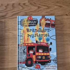 Brandkårsmysteriet - Följ med LasseMajas Detektivbyrå när de löser ett spännande mysterium kring brandkåren i Valleby! Perfekt för unga deckarfans som gillar äventyr, kluriga gåtor och färgglada illustrationer.