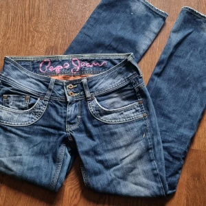 Utsvängda lågmidjade jeans - Lågmidjade utsvängda / bootcut jeans från det populära y2k märket Pepe Jeans. Inga defekter och nästintill aldrig använda eftersom dem är lite för korta för mig. Utan storleksmärkning, passar troligen någon som bär S / M i storlek. Kolla mått innan.  • Mått: Midja: 38 cm Full längd: 97 cm Innebens längd: 76cm  Fråga gärna ifall ni vill ha fler bilder eller frågor :)