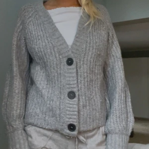 Grå stickad kofta  - Mysig grå stickad kofta från Stories. Så skön och passar till allt!