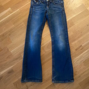 Mörkblå jeans stl 140 – Gina Tricot -  jeans i mörkblå denim som tappat lite färg och har ett slitet avslut nertill, dom är lite vita vid knäna och där bak vid fickorna och dom är bootcut 