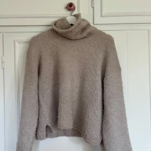 Beige fluffig polotröja stickad - Supermysig beige polotröja från Bikbok. Fluffig o mjuk. Hög krage, lite mindre i storleken. Använd fåtal gånger, bra skick🤍