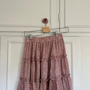 Rosa leopardmönstrad volangkjol - Säljer en superfin rosa kort kjol med vitt leopardmönster och flera volanger. Resår i midjan, perfekt till sommaren☀️Aldrig använd