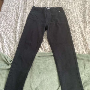 Svarta skinny jeans från Calvin Klein - Snygga svarta jeans från Calvin Klein med klassisk CK-logo på fickan. Modellen är skinny med smal passform och midja. Jeansen har fem fickor och är gjorda i mjukt bomullsmaterial med lite stretch för extra komfort.