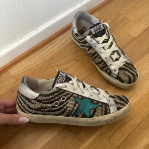 Golden Goose superstars zebra - Golden Goose superstars i zebra mönster med blå stjärna, skorna är i väldigt gott skick och är i storlek 36.(Endast skor och en lapp från goldengoose medföljer i köpet)