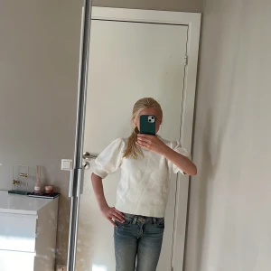 Vit stickad tröja med puffärm Gina Tricot - Supersöt vit stickad tröja från Gina Tricot med puffiga korta ärmar och ribbad kant vid hals, ärmslut och nederkant. Perfekt för dig som gillar en clean och fräsch look med lite extra volym på axlarna. Oanvänd 