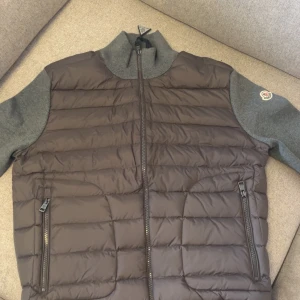 Moncler cardigan - Säljer en helt ny och oanvänd Moncler cardigan/ jacka i stilren grà färg. Storlek L passar M ochsá. Perfekt för dig som vill ha en exklusiv, bekväm och snygg jacka som funkar bäde till vardags och lite finare tillfällen. Pris kan diskuteras!