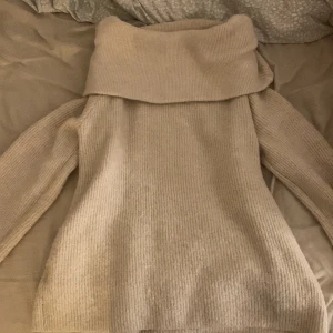 Beige stickad polotröja från H&M - Mysig beige stickad polotröja från H&M med bred krage och ribbad struktur. Perfekt för lager-på-lager och chill höst- och vinterstil. Långärmad och i en loose fit som ger en avslappnad vibe.
