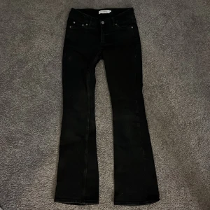 Svarta bootcut jeans från Junkyard XS - Snygga svarta jeans från Junkyard i bootcut-modell, Lågmidjade!!Jeansen har klassisk femficksdesign, svarta sömmar och subtila detaljer på bakfickan. Perfekta för dig som gillar en stilren look. Använda max 2 gånger i stort sätt helt nya