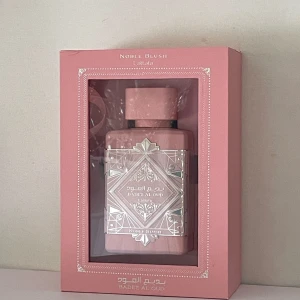Lattafa Bade'e Al Oud Noble Blush EdP 100ml - Lattafa Noble Blush från Lattafa är en Eau de Parfum på 100ml.  Rosmjölk, marräng, mandlar, vanilj, mysk och sandelträ. Top note is Rose Milk; middle notes are Meringue and Almond; base notes are Vanilla, Musk and Sandalwood. Det är en pudrig, mjuk och krämig feminin parfym.  Fräsch fast ändå mjuk. Se sista bilden för mängd kvar. 85-90ml kanske? 