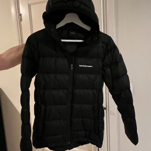 Peak Performance jacka - Säljer en svart dunjacka från Peak Performance i mycket bra skick. Jackan har en dragkedja framtill och en praktisk huva. Perfekt för kalla vinterdagar!! ❄️❄️