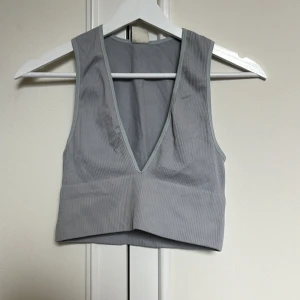 Ljusblå ribbad crop top - Stretchiga ribbad crop top, djup v-ringning. Använd 1 gång!