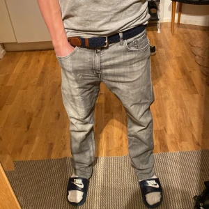 Grå jeans från Replay - Snygga grå jeans från Replay med en klassisk femficksdesign. De har en straight passform och är tillverkade i ett bekvämt denimtyg. Perfekta för en avslappnad stil. Litet brunt märke på sista bilden syns inte