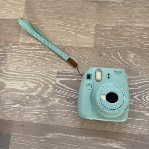 Kamera  - Säljer min ljusblå/turkosa kamera. Den är använd yterstlite och är i väldigt fint skick. Instax mini 9, ny pris 800