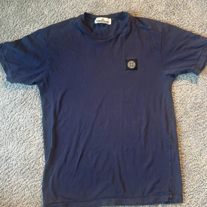Blå t-shirt från Stone Island - Snygg marinblå t-shirt från Stone Island i bra skick.