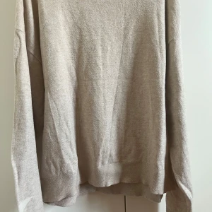 Beige stickad tröja med stjärna Gina Tricot - Beige stickad tröja från Gina Tricot i storlek 158/164. Tröjan har lång ärm och en vit stjärndetalj på ena ärmen. Mjuk och skön, perfekt för kyligare dagar. Enkel och stilren design som passar till det mesta.