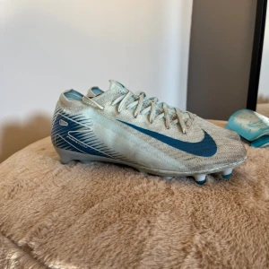 Nike Mercurial Zoom Elite fotbollsskor blå/vit - Nike Mercurial Zoom Elite fotbollsskor i ljusblått och vitt med blå Nike-logga. Skorna är i storlek 38,5. Syns att de är använda men funkar perfekt.