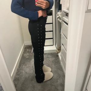 Coola svarta jeans med snörning - Säljer ett par svarta jeans med cool snörningsdetalj längs hela sidan av benen. Skriv vid frågor eller liknande💕