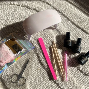 Nagelkit med gel-lack och UV-lampa  - Komplett nagelkit med tre gel-lack från Rosalind i lila och rosa nyanser (C097, C066, C417), UV-lampa från SUNmini i ljusrosa, nagelfil, nagelverktyg, sax, och nagelstickers. Perfekt för att fixa snygga naglar hemma med proffsigt resultat.