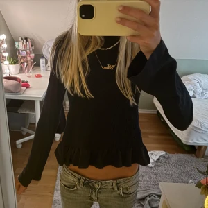 Mörkblå långärmad tröja smockad - Supersöt mörkblå tröja med smockad front och volangkant nertill. Långärmad modell med rund hals och lätt utsvängda ärmar. Har bara andvänt den ett fåtal gånger så ser ut som ny. Storleken är 146-152 och den passar bra på mig som är 167 så det är som en XS/S om man vill ha den tajt