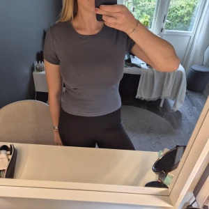 Mörkgrå t-shirt Gina Tricot - En grå t-shirt från Gina tricot i en lite kortare modell❣️passar mig som har S