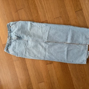 Ljusblå lång jeanskjol från nakd - Säljer en snygg ljusblå lång jeanskjol från NAKD med klassisk femficksdesign och knappstängning fram. Kjolen har rak passform och en diskret slits baktill för extra rörelsefrihet. Perfekt för dig som gillar den tidlösa denimlooken.