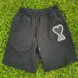 Svarta AMI Paris Shorts - Svarta shorts från Ami Paris med elastisk midja och snörning. På vänster ben finns en stor broderad logga. Perfekta för sommaren och riktigt sköna att ha på sig. Går även att köpa i ett set, checka in profilen! 🤩☀️