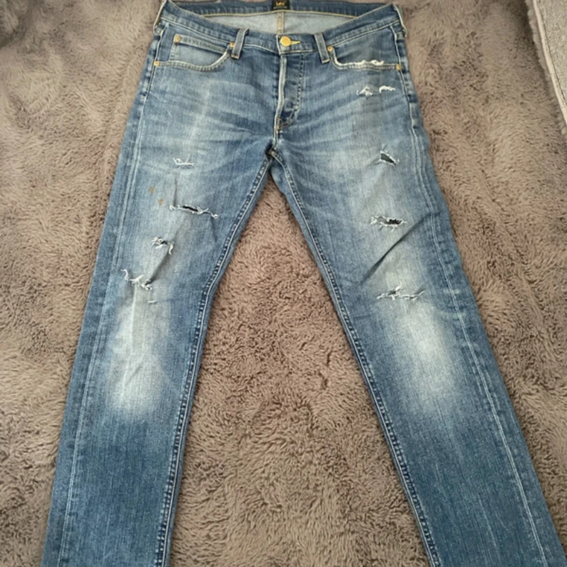 Blå slitna jeans från Lee