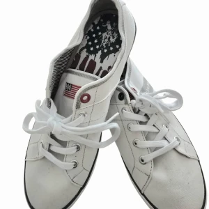 Vita sneakers med amerikansk flagga - Knappt använt snygg vita sneakers från US Polo Assn. med klassisk snörning och rund tå. Skorna har en liten amerikansk flagga på sidan och ett unikt mönster på innersulan med stjärnor och ränder. Perfekta för en avslappnad och stilren look.