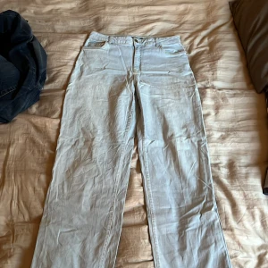 Ljusblå jeansbyxor från Boohoo Tall - Säljer ett par ljusblå jeansbyxor från Boohoo Tall med hög midja och raka ben. Klassisk femficksmodell med gylf och knapp framtill. Perfekta för dig som vill ha en enkel och stilren look.