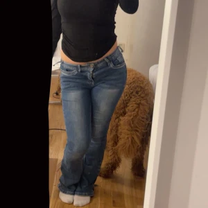Blå bootcut jeans med broderade fickor - Säljer ett par blå bootcut jeans med snyggt broderade bakfickor i vitt. Jeansen har mellan-låg midja och är bootcut. Storlek Xs. Pris kan diskuteras 