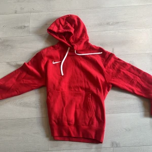Röd hoodie från Nike - Säljer en klassisk röd hoodie från Nike med vit logga på bröstet. använd få antal gånger.