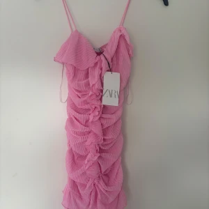 Rosa volangklänning från Zara - Rosa klänning från Zara. Prislappen är kvar alltså helt ny men köpt från plick.